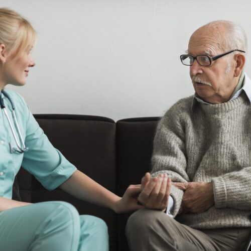 nurse-consoling-old-man-nursing-home